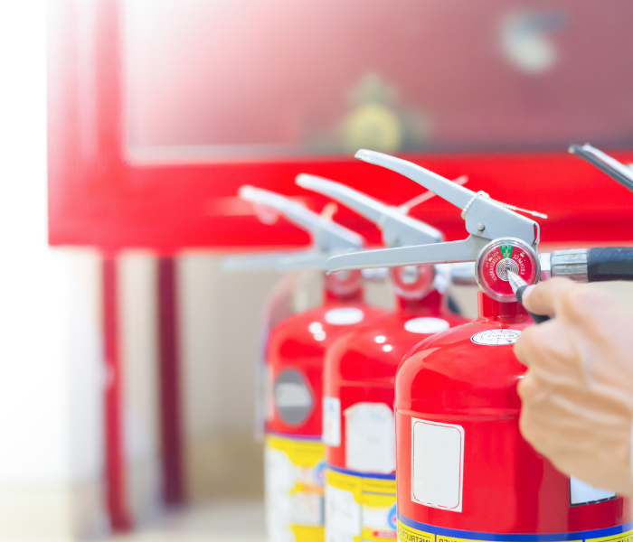 Three fire extinguishers ready to be used.